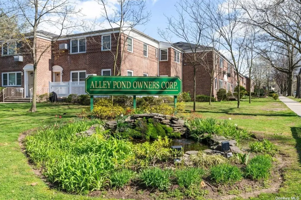 A green sign sitting in front of some buildings.